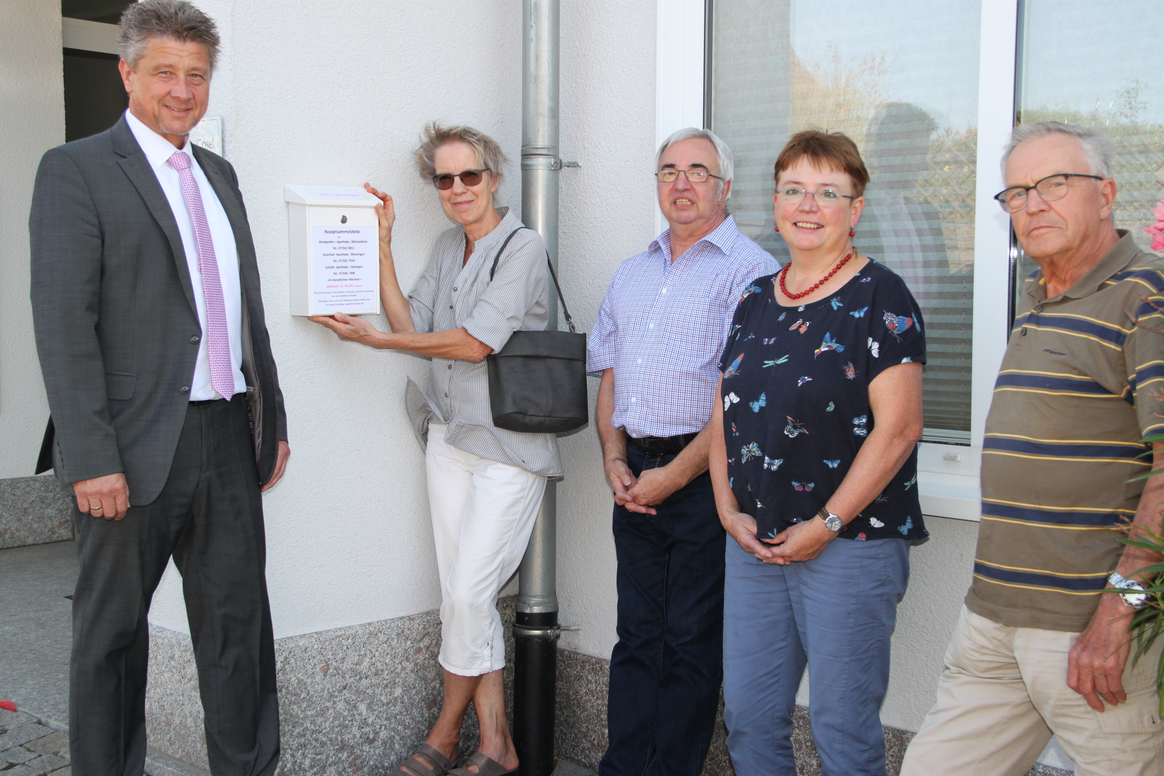 Bürgermeister Ulrich Hintermayer (links) zusammen mit den drei Apothekern Dorothea Haßler (von links), Martin Bratler, Theresia Bschorer-Krause und Hausbesitzer Karl Kern am Gebäude der Praxis Dr. Neumann-Cosel in der Hauptstraße 131 in Kraichtal-Gochsheim, wo der „Briefkasten“ zum 1. Oktober hängen wird.