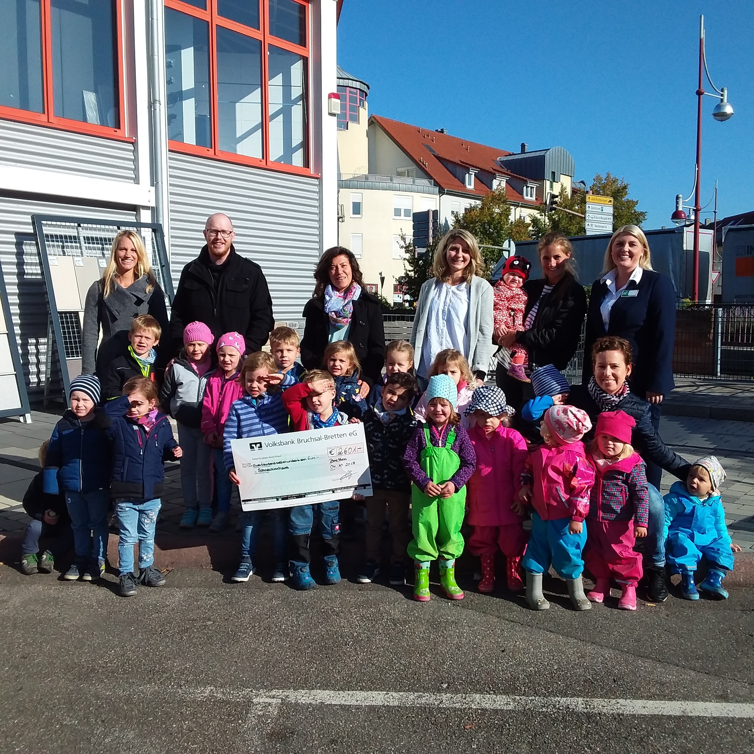 Freude über finanzielle Unterstützung: Kinder und Betreuer der Schneckenhaus-Kitas mit Hagebaumarkt-Marktleiterin Melanie Goldschmidt (rechts hintere Reihe) bei der Scheckübergabe.