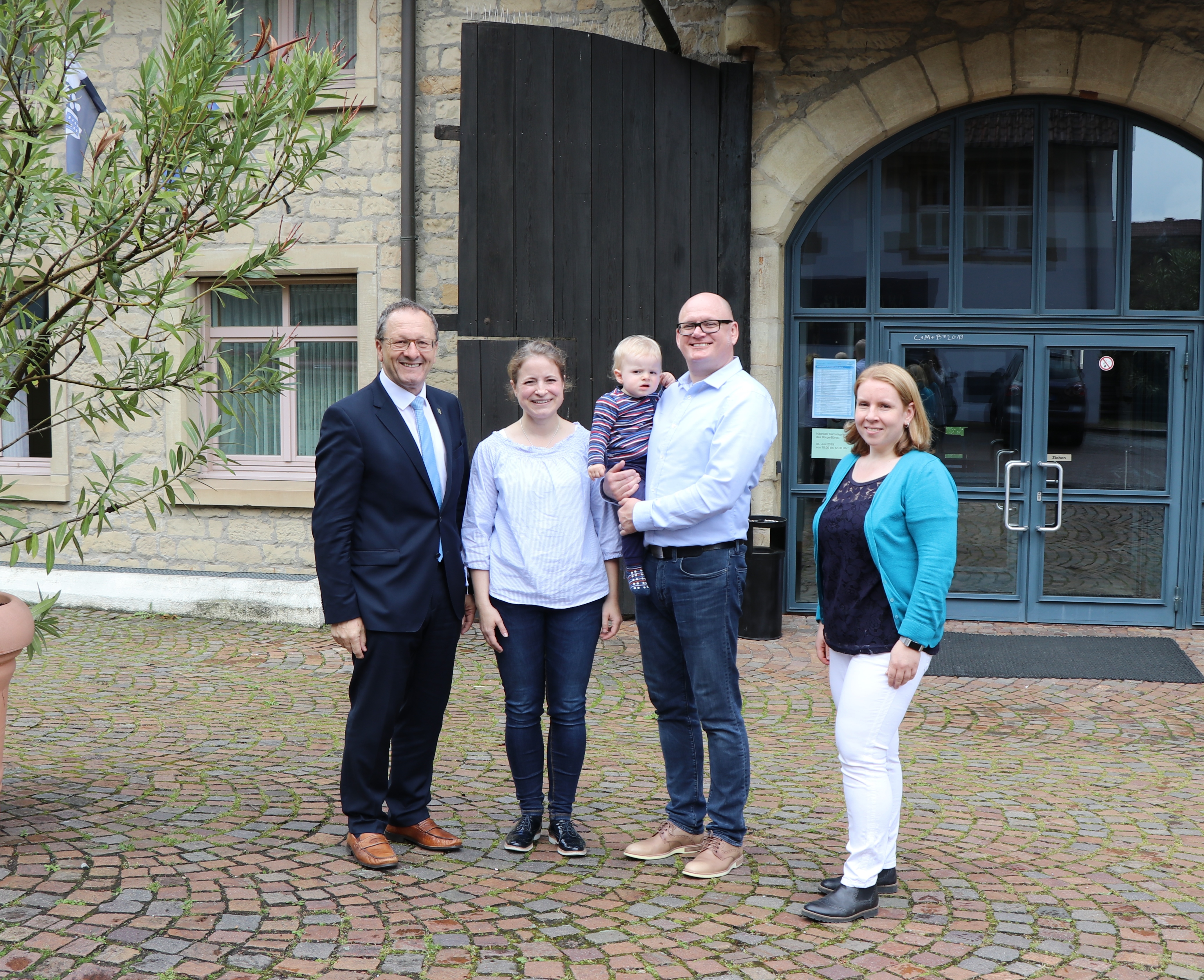 Bürgermeister Thomas Nowitzki (links) und Silvia Reiner (rechts), Leiterin des BürgerBüros Oberderdingen, begrüßen Familie Kirste.